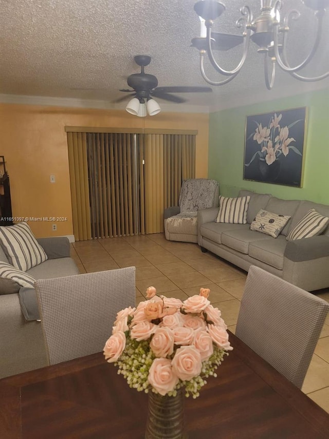 tiled living room with ceiling fan with notable chandelier and a textured ceiling