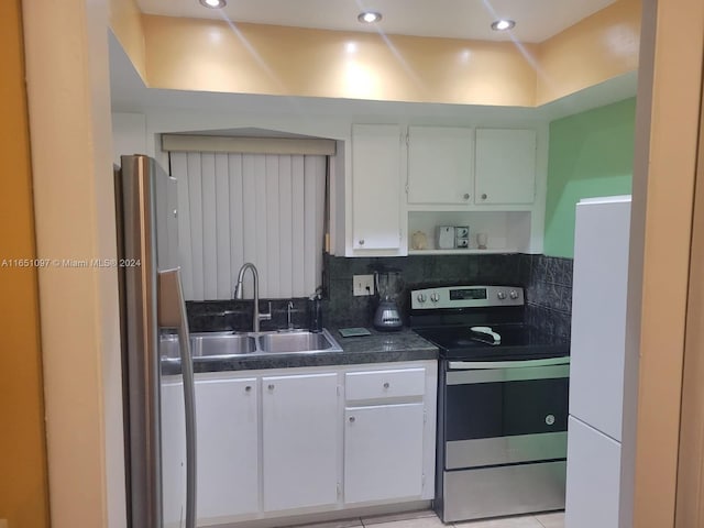 kitchen featuring stainless steel appliances, sink, backsplash, and white cabinets