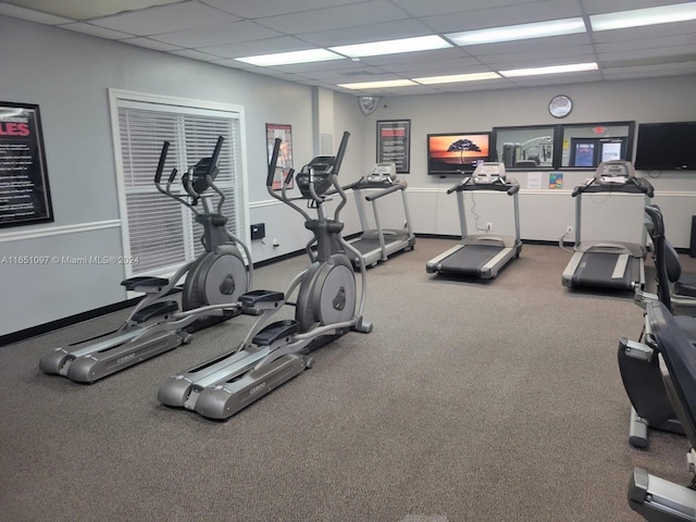 workout area with a paneled ceiling and carpet flooring