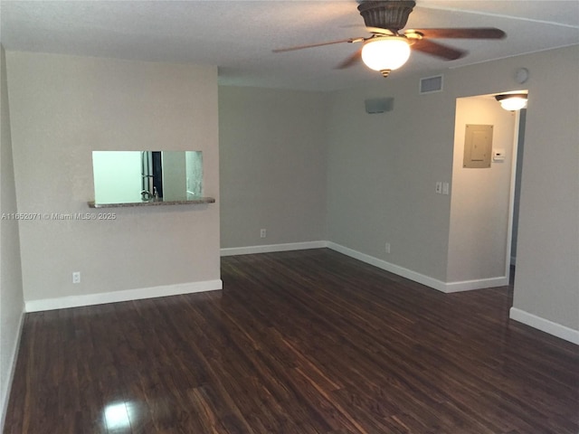 empty room featuring visible vents, dark wood finished floors, and baseboards