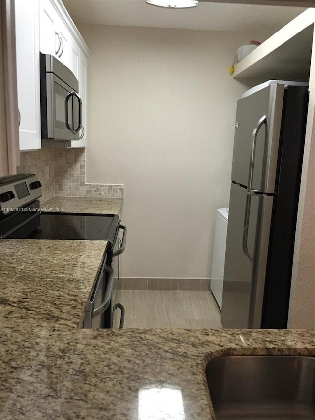 1028 Twin Lakes Dr Unit 21-C, Coral Springs, FL 33071 - kitchen featuring stainless steel appliances, white cabinetry, light stone counters, backsplash, and baseboards