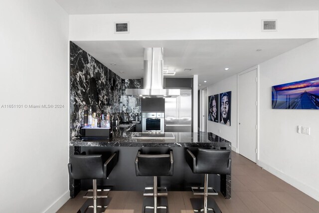 1100 Biscayne Blvd Unit 4004, Miami, FL 33132 - kitchen featuring a kitchen breakfast bar, appliances with stainless steel finishes, island range hood, and visible vents
