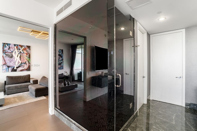 bathroom featuring a shower with door