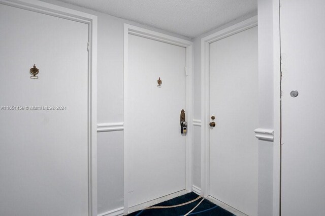 doorway featuring a textured ceiling