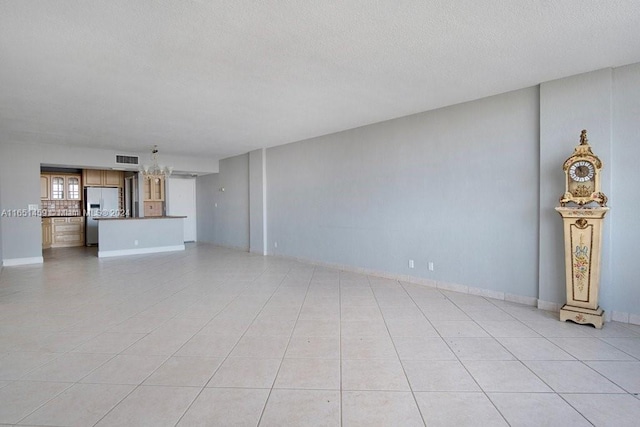 unfurnished living room with a textured ceiling and light tile patterned floors