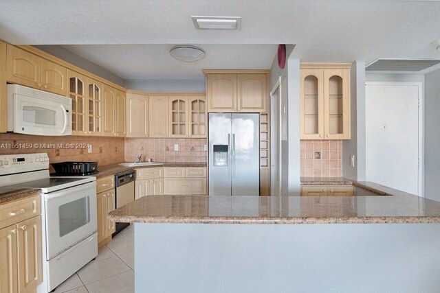 kitchen with appliances with stainless steel finishes, light stone counters, and backsplash