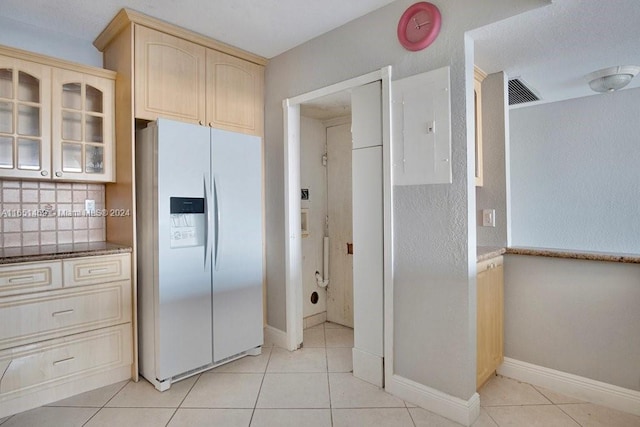 kitchen with electric panel, light tile patterned floors, decorative backsplash, and white fridge with ice dispenser