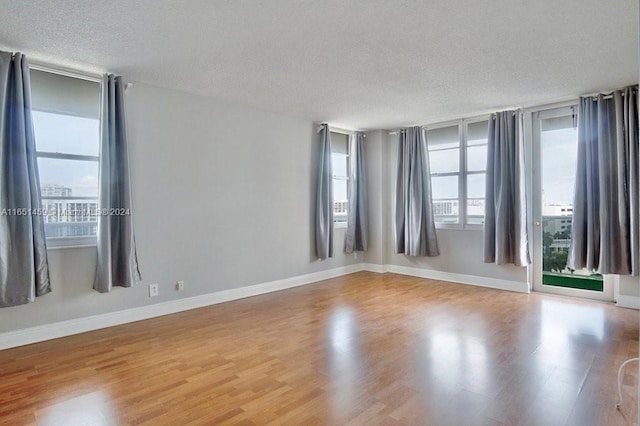 empty room with hardwood / wood-style flooring and a textured ceiling