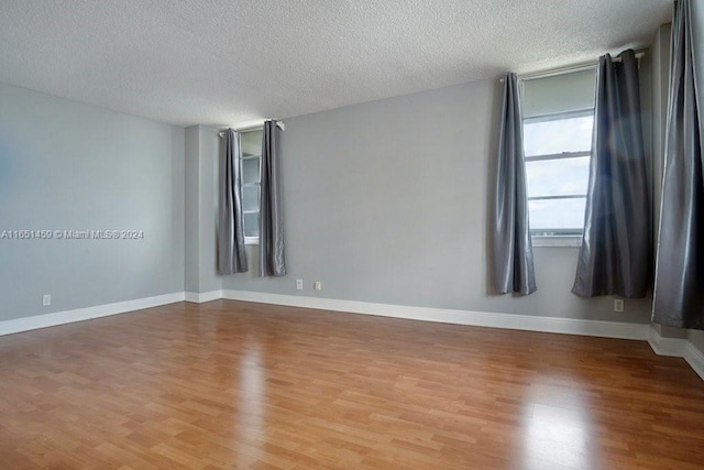 unfurnished room featuring hardwood / wood-style floors and a textured ceiling