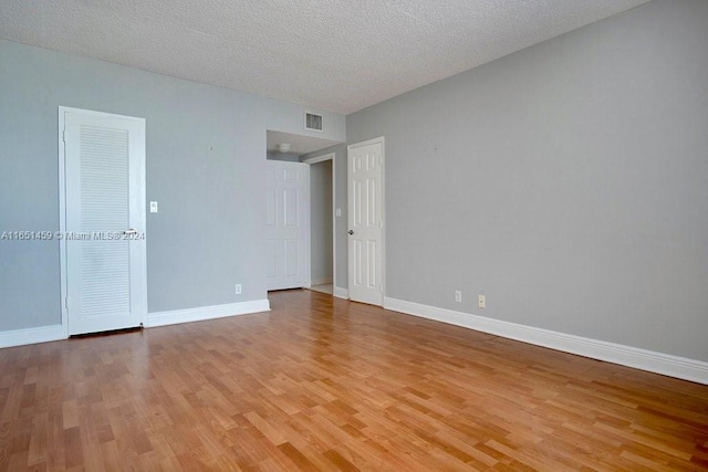 unfurnished bedroom with a textured ceiling and light hardwood / wood-style flooring