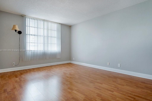 empty room featuring light wood-type flooring and a textured ceiling