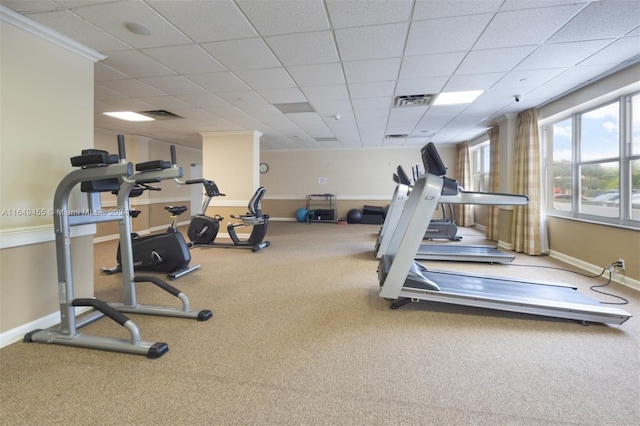 workout area featuring ornamental molding, a paneled ceiling, and carpet flooring