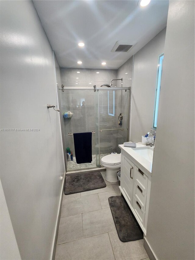 bathroom featuring an enclosed shower, tile patterned flooring, toilet, and vanity