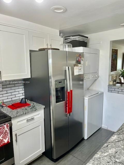 kitchen featuring light stone counters, white cabinets, appliances with stainless steel finishes, dark hardwood / wood-style flooring, and decorative backsplash