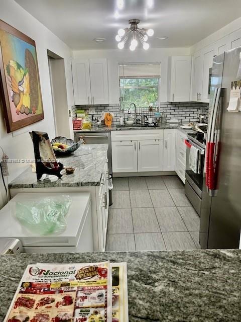 kitchen with stainless steel appliances, white cabinets, and sink