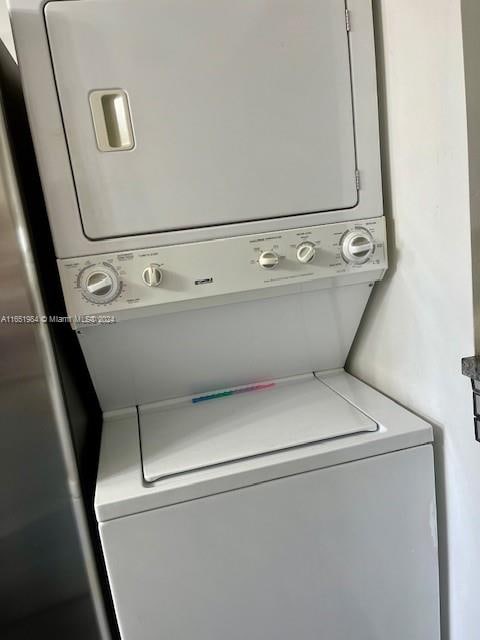 clothes washing area with stacked washer and clothes dryer