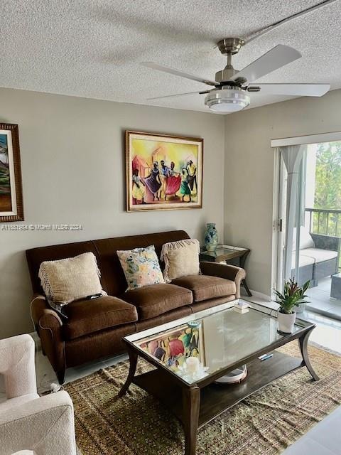 living room featuring ceiling fan and a textured ceiling