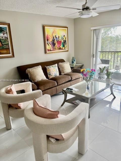 tiled living room featuring ceiling fan and a textured ceiling