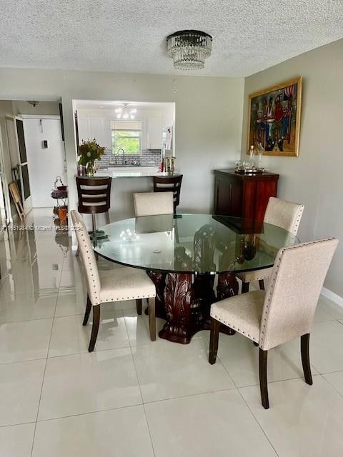 dining area with a textured ceiling and light tile patterned floors