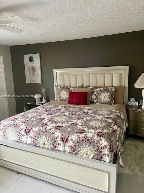 tiled bedroom with a textured ceiling and ceiling fan