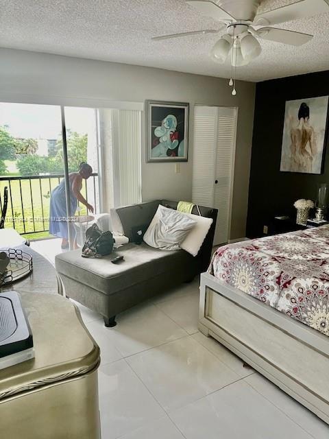 tiled bedroom featuring ceiling fan, access to exterior, and a textured ceiling