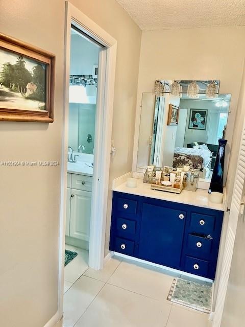 bathroom with a textured ceiling, vanity, and tile patterned floors