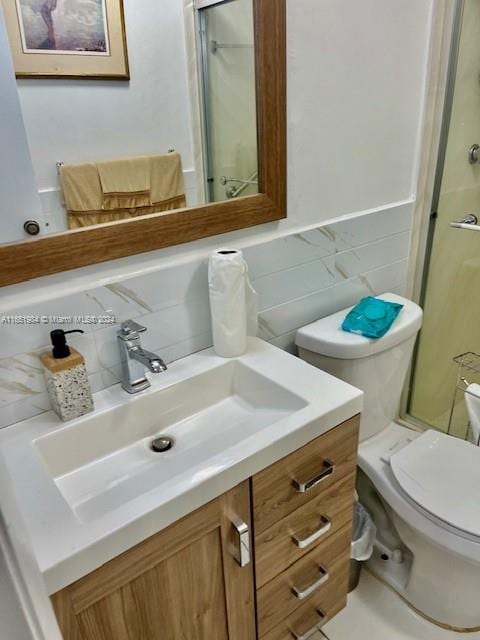 bathroom featuring vanity, toilet, and an enclosed shower