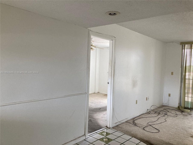 carpeted empty room featuring a textured ceiling and ceiling fan