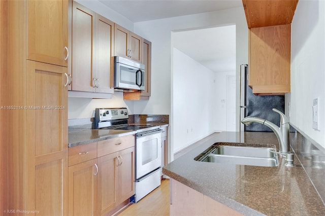 kitchen featuring light hardwood / wood-style flooring, light brown cabinets, stainless steel appliances, and sink