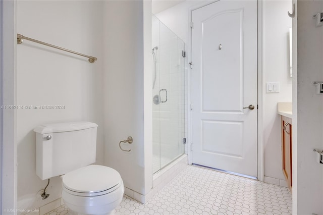 bathroom with vanity, toilet, and a shower with shower door