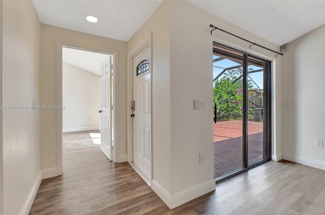 unfurnished room featuring ceiling fan, vaulted ceiling, a textured ceiling, and light hardwood / wood-style flooring