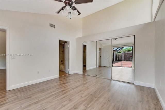 unfurnished bedroom with high vaulted ceiling, light hardwood / wood-style flooring, access to outside, ceiling fan, and a closet