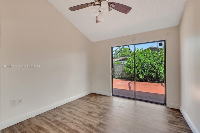 spare room with a textured ceiling, ceiling fan, light wood-type flooring, and vaulted ceiling