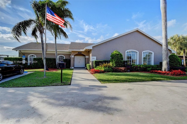 ranch-style house featuring a garage and a front lawn