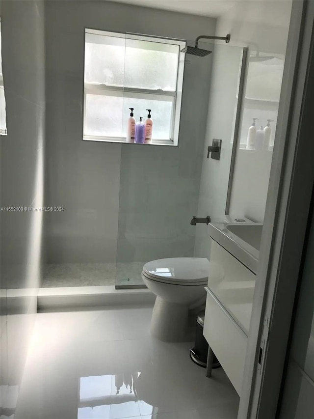 bathroom featuring vanity, toilet, a shower, and tile patterned flooring