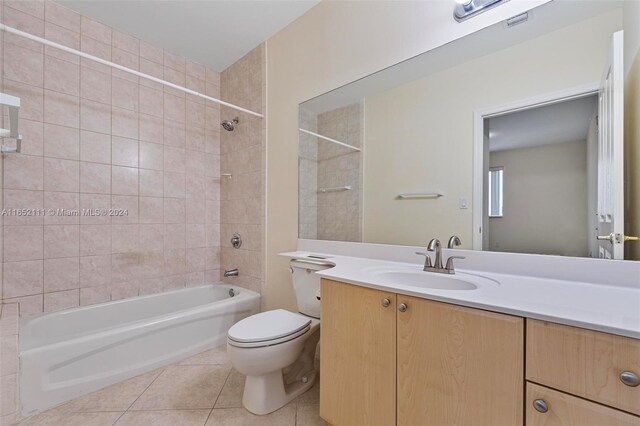 full bathroom with tile patterned flooring, vanity, tiled shower / bath combo, and toilet