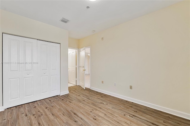 unfurnished bedroom featuring a closet and light hardwood / wood-style flooring