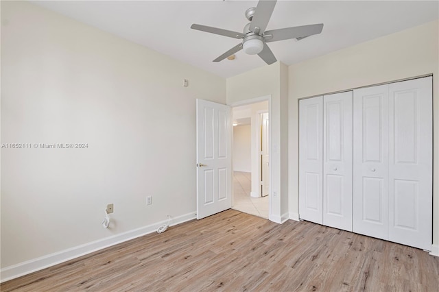 unfurnished bedroom with ceiling fan, a closet, and light hardwood / wood-style flooring