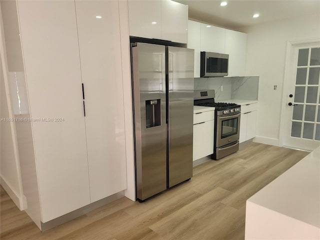 kitchen featuring white cabinetry, light hardwood / wood-style flooring, stainless steel appliances, and tasteful backsplash