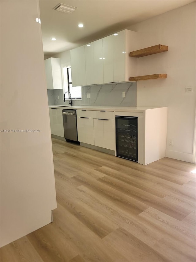 kitchen with dishwasher, white cabinetry, beverage cooler, and light hardwood / wood-style floors