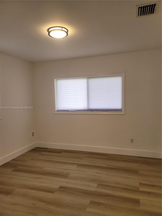 spare room featuring a wealth of natural light and light hardwood / wood-style floors