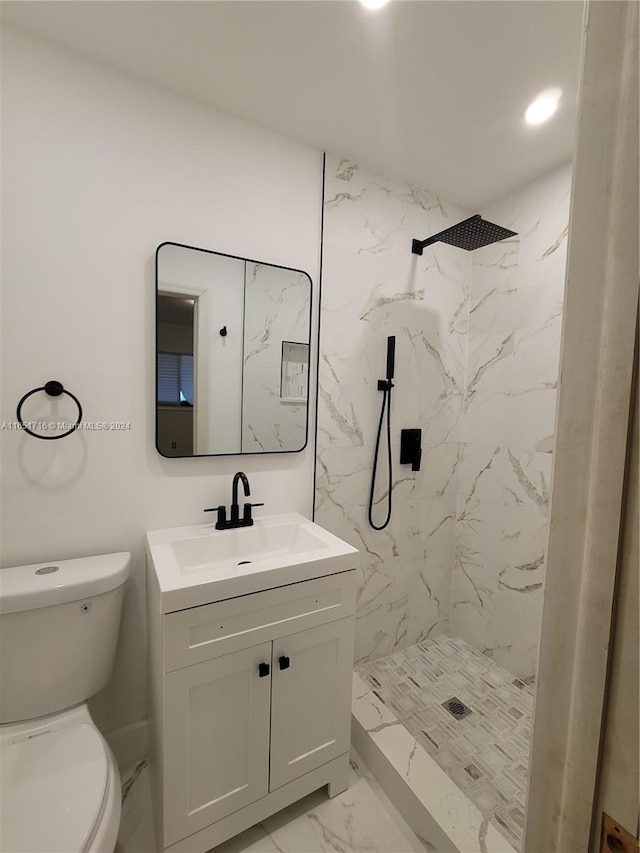 bathroom featuring vanity, toilet, and tiled shower