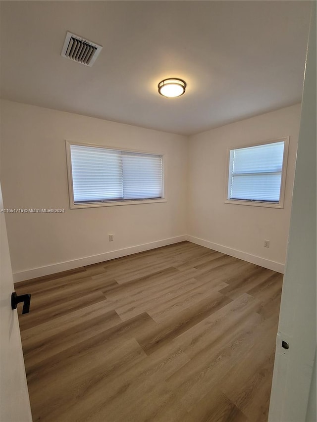 unfurnished room with hardwood / wood-style flooring