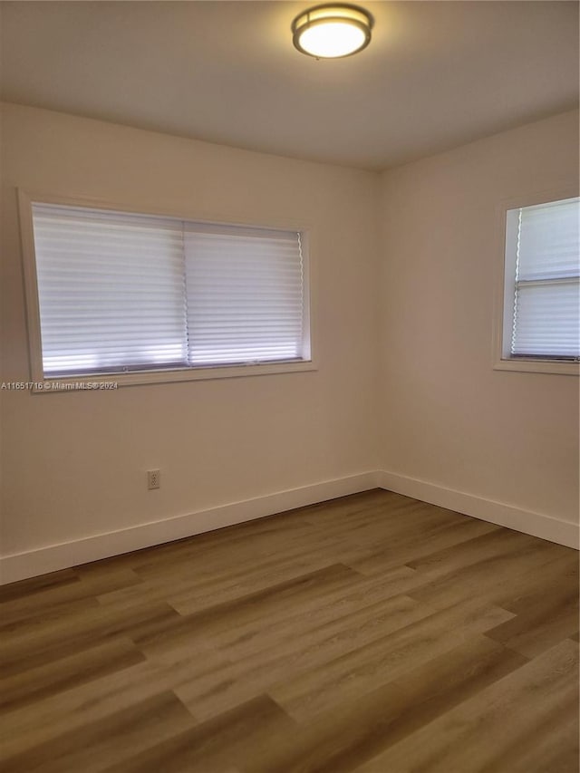 unfurnished room with hardwood / wood-style floors