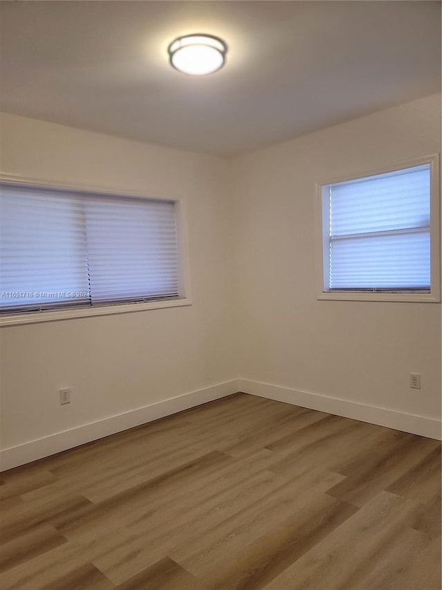 unfurnished room with wood-type flooring