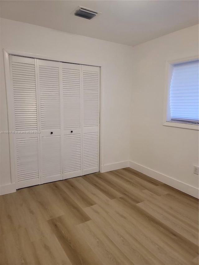 unfurnished bedroom featuring a closet and light hardwood / wood-style flooring