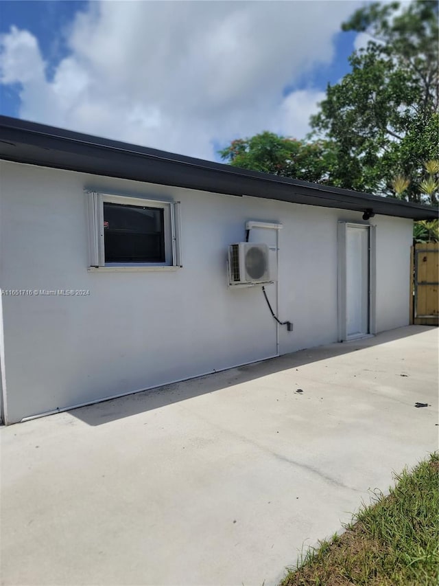 view of side of property featuring ac unit and a patio area