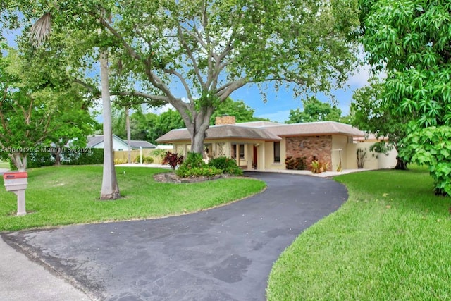 single story home with a front lawn