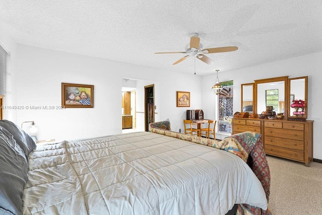 carpeted bedroom featuring a textured ceiling and ceiling fan