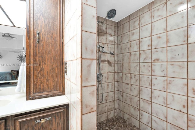 bathroom featuring tiled shower and vanity